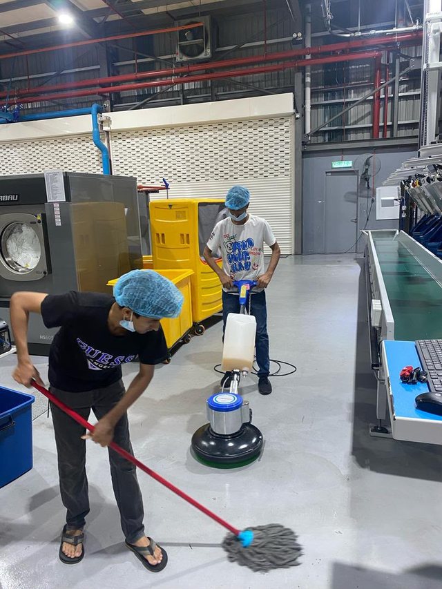Nexo cleaning crew of two team members scrubbing a factory floor together
